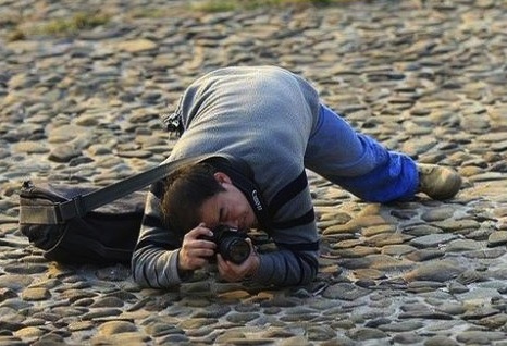 Young Man In Siting On The Ground, Video Camera Man Pose And Looking At  Camera Stock Photo, Picture and Royalty Free Image. Image 89897016.