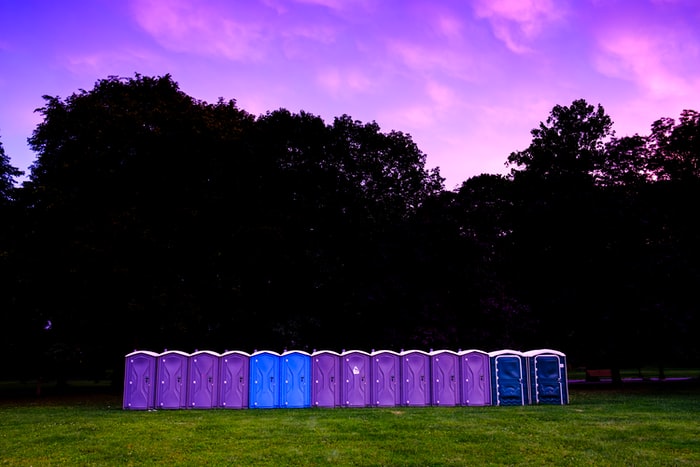 photography of portable toilet on field