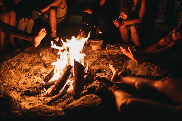 people sitting near bonfire during night time