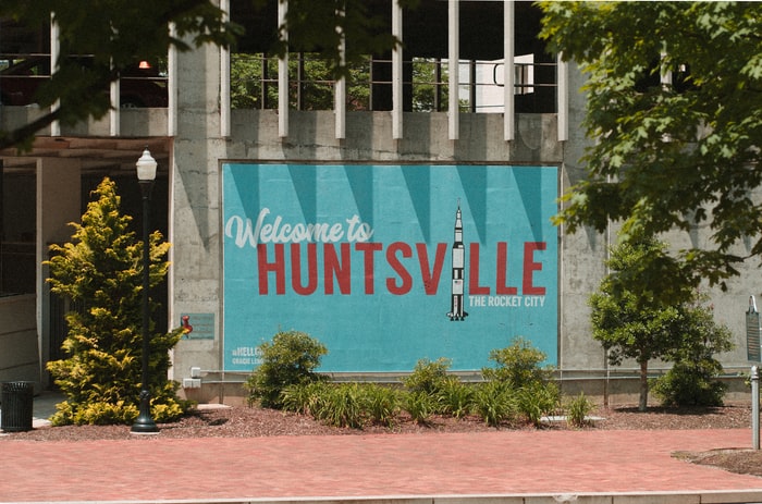 welcome to Huntsville sign on wall near trees and lamppost