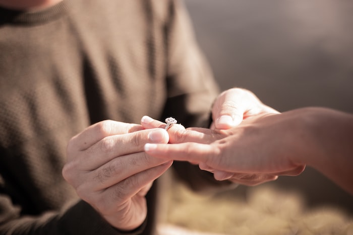 person holding silver diamond ring