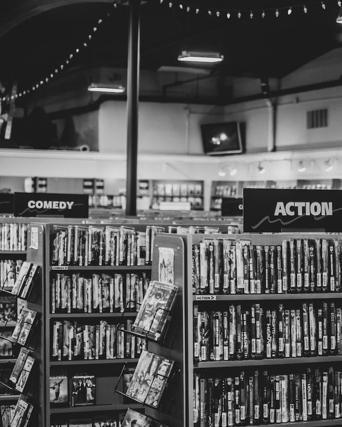 grayscale photo of books on shelves