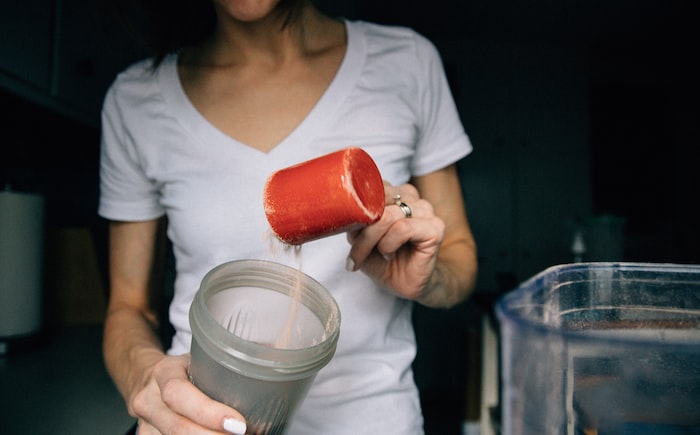 woman in white crew neck t-shirt holding red plastic cup