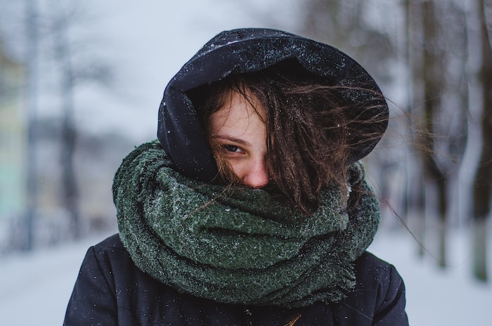 woman wearing hoodie under green scarf